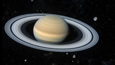 Saturn and its rings with many small distant moons in deep space