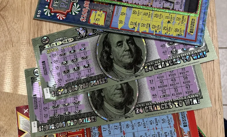 Hands holding scratched lottery tickets